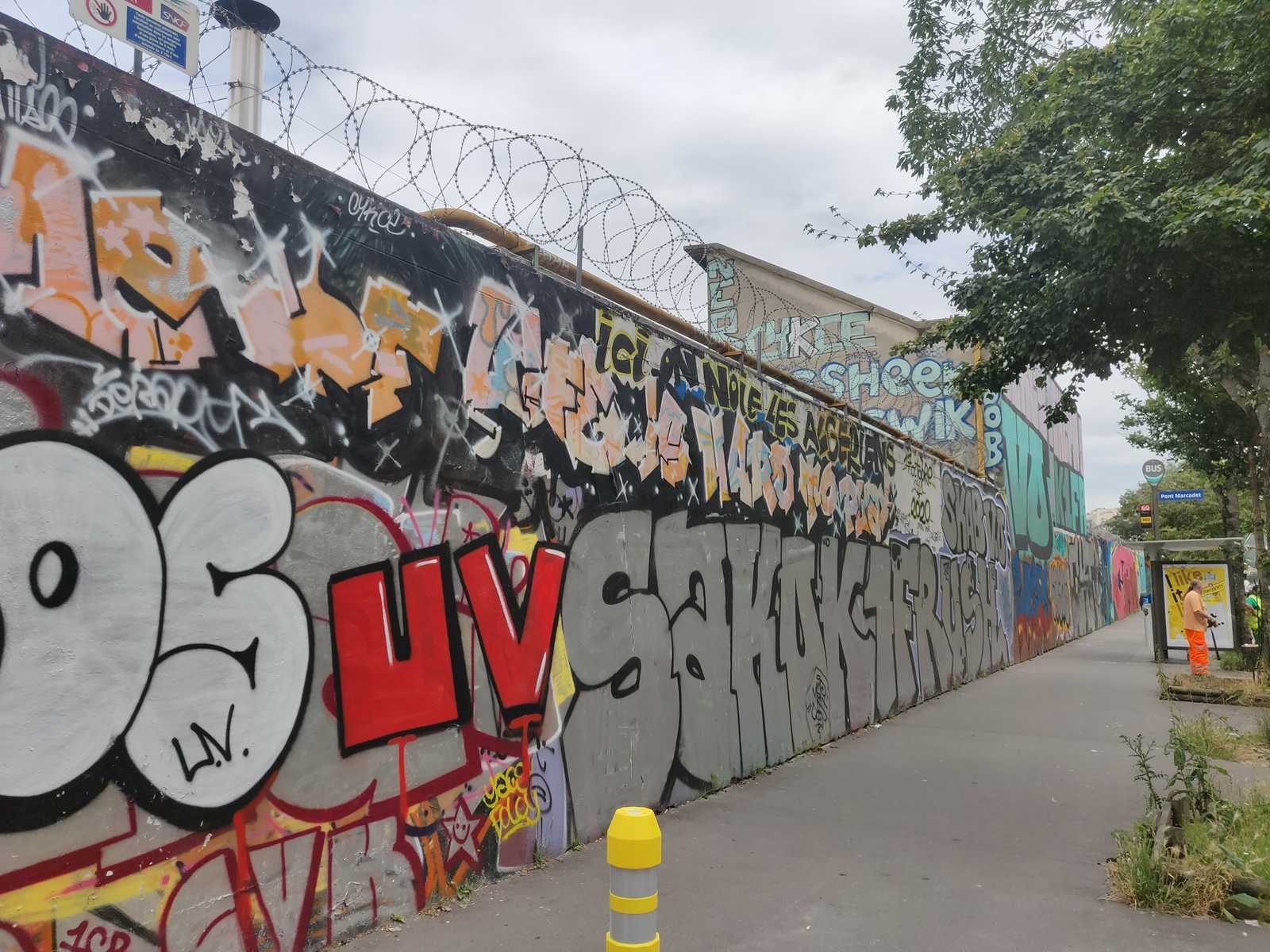 Fußgängerweg entlang der Graffiti Hall of Fame von Paris, urbane Kunst, urbanität, rotes UV-Graffiti, Chrom-Graffiti SAKO, K1FR, RUSH, Großes Roll-up auf Höhe Bushhaltestelle VO-Graffiti Paris Nord, Urbane Kultur Frankreich